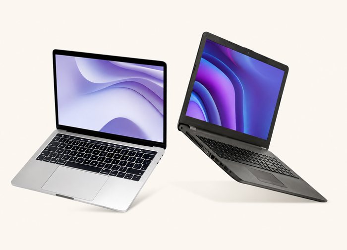 A silver ultrabook and a black business laptop, both open, side by side.