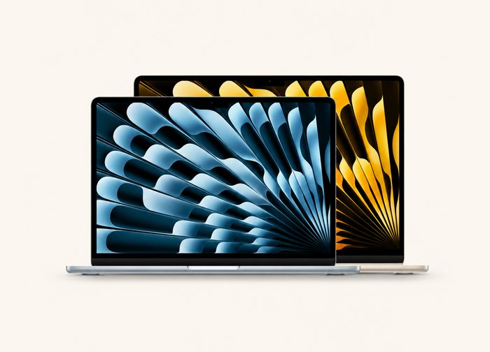 Two MacBooks standing open side by side, a smaller silver one in front of a larger gold one.