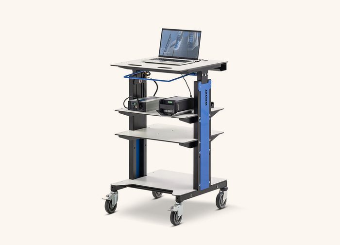 A wheeled equipment trolley with a laptop on the top shelf and power units on the shelf below.